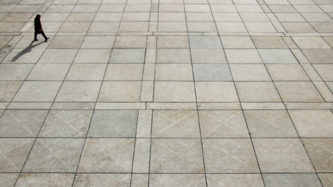 Man walking across concrete square